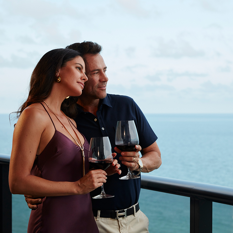 A couple enjoying a glass of wine and their view of the ocean